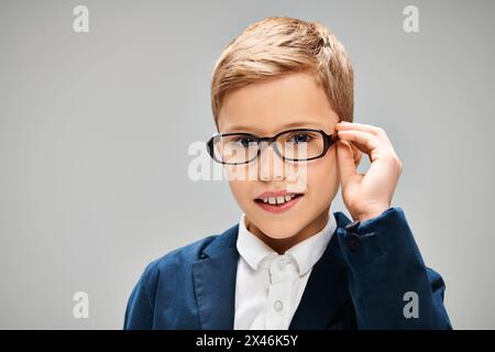 Ein kleiner Junge in Brille und Anzug, der Intelligenz und Eleganz ausstrahlt. Stockfoto