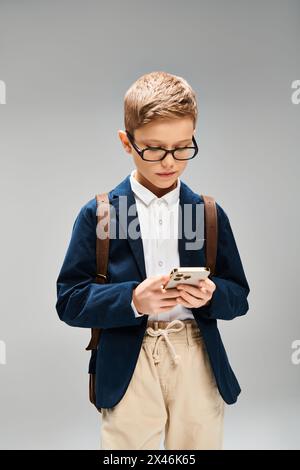 Ein vorpubertärer Junge in blauer Jacke und Brille sieht fleißig aus. Stockfoto