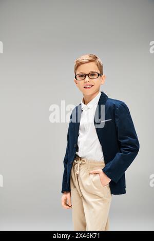 Vorpubertärer Junge in stilvollem Anzug und Brille, der Selbstvertrauen und Raffinesse ausstrahlt. Stockfoto