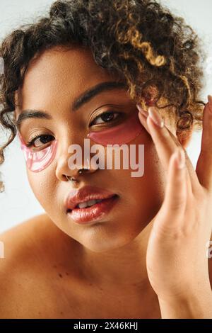 Eine schöne afroamerikanische Frau aus der Nähe mit Augenflecken vor einer lebendigen Kulisse. Stockfoto