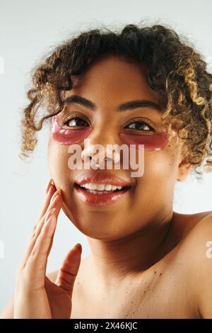 Afroamerikanerin mit rosa Augenflecken posiert kreativ. Stockfoto