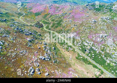 Drohnenansicht einer kurvigen Straße in einem bergigen Gebiet im Frühling. Galicien, Spanien. Stockfoto