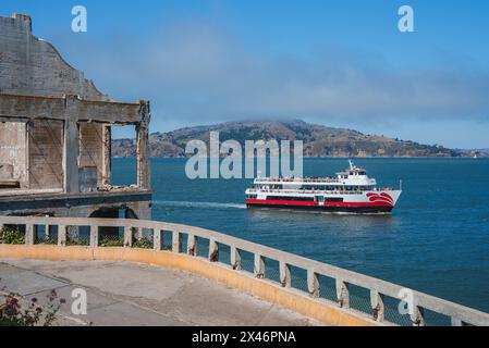 Verfallende Ruinen stehen im Kontrast zur modernen Fähre mit Blick auf die Bucht von San Francisco von Alcatraz Island. Stockfoto