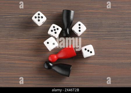 Viele weiße Würfel und Farbspielstücke auf Holztisch, flach gelegt Stockfoto