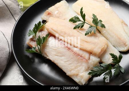 Teller mit rohen Kabeljau und Petersilie auf Lichttisch, Nahaufnahme Stockfoto