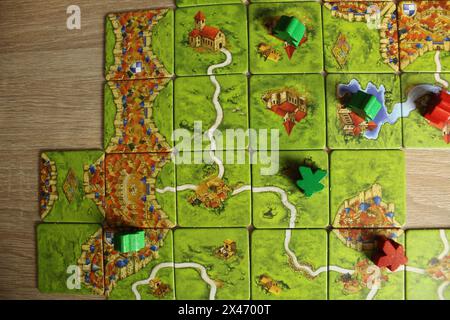 Mozyr, Weißrussland, 03. April 2024: Grüne und rote Meeples liegen auf der Karte im Spiel carcassonne Draufsicht. Stockfoto