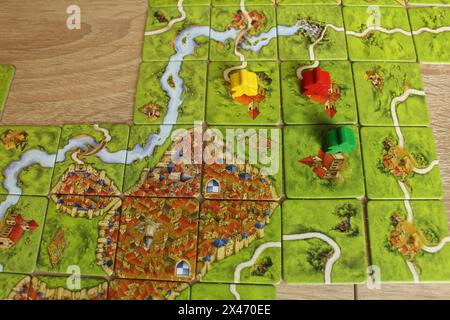 Mozyr, Weißrussland, 03. April 2024: Das Spielfeld des Brettspiels carcassonne. Bunte Meeples auf dem Spielfeld. Stockfoto