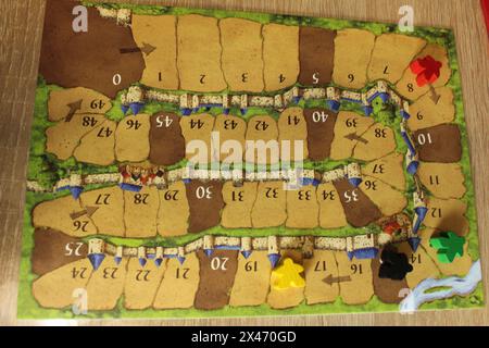 Mozyr, Weißrussland, 03. April 2024: Tablette zur Berechnung des Fortschritts der Spieler im Brettspiel Carcassonne. Rot Gelb Melinierter Schwarzer Meeple Stockfoto