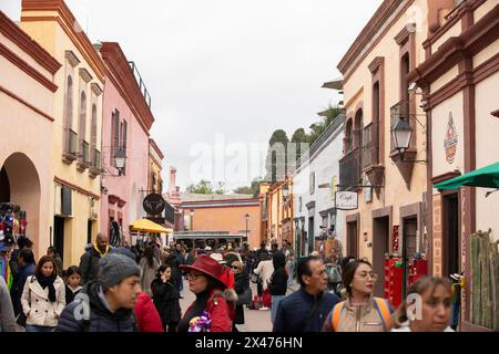 Bernal, Querétaro, Mexiko - 20. November 2023: Touristen schlendern entlang der historischen Gebäude des historischen Stadtzentrums von Bernal. Stockfoto