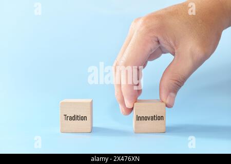 Die Wahl von Innovation statt Traditionskonzept. Holzblöcke auf blauem Hintergrund. Stockfoto