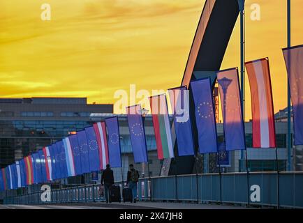 1. Mai 2024, Brandenburg, Frankfurt (oder): Zwei Reisende überqueren bei Sonnenaufgang die Stadtbrücke über die oder-Grenze zwischen Frankfurt (oder) und Slubice in Polen. Die Außenminister der beiden Nachbarländer wollen sich mittags zum 20. Jahrestag des EU-Beitritts Polens treffen. Beide wollen das Collegium Polonicum in Slubice auf polnischer Seite besuchen, sowie ein europäisches Festival, und dann gemeinsam über die Stadtbrücke über die deutsch-polnische Grenze oder nach Frankfurt (oder) laufen. Foto: Patrick Pleul/dpa Stockfoto