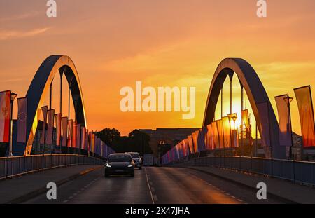 01. Mai 2024, Brandenburg, Frankfurt (oder): Bei Sonnenaufgang fahren Autos über die Stadtbrücke über die oder-Grenze zwischen Frankfurt (oder) und Slubice in Polen. Am 20. Jahrestag des EU-Beitritts Polens wollen sich die Außenminister der beiden Nachbarländer um Mittag treffen. Beide wollen das Collegium Polonicum in Slubice auf polnischer Seite besuchen, sowie ein europäisches Festival, und dann gemeinsam über die Stadtbrücke über die deutsch-polnische Grenze oder nach Frankfurt (oder) laufen. Foto: Patrick Pleul/dpa Stockfoto