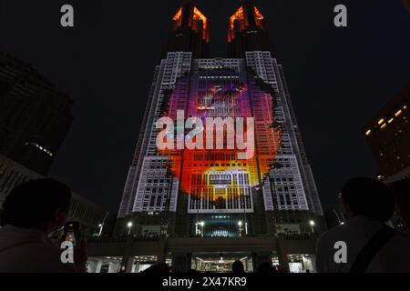 Tokio, Japan. April 2024. Die Leute sehen die Godzilla Show beim Tokyo Night and Light Projektion Mapping Projekt im Tokyo Metropolitan Government Tower 1 in Shinjuku. Die nächtliche Ausstellung des größten permanenten Projektionskartierungsprojekts der Welt begann im Februar 2024 und deckt etwa 905 m2 der Fassade des Wahrzeichens Tokio ab. Am 27. April 2024 wurde eine Ausstellung vorgestellt, in der Godzilla Tokio angreift. Quelle: SOPA Images Limited/Alamy Live News Stockfoto