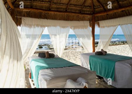 Karibischer Strand- und Meeresblick-Hütte-Spa mit leerem Massagetisch, bietet potenziellen Kunden Panoramablick und Entspannung in Mexiko Stockfoto