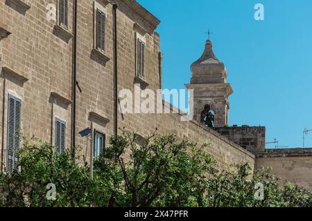 Glockenturm in Polignano a Mare, wunderschöne Stadt mit einem Strand zwischen den Klippen der Stadt. Farbenfrohes Bild eines malerischen Dorfes im italienischen apulien auf einem Stockfoto