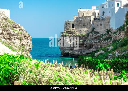Polignano a Mare, wunderschöne Stadt mit einem Strand zwischen den Klippen der Stadt. Farbenfrohes Bild eines malerischen Dorfes in italienisch-apulien an einem sonnigen Frühlingsbad Stockfoto