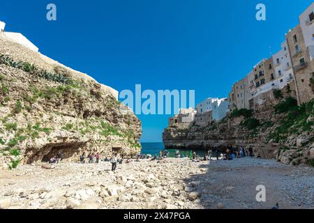 Polignano a Mare, wunderschöne Stadt mit einem Strand zwischen den Klippen der Stadt. Farbenfrohes Bild eines malerischen Dorfes in italienisch-apulien an einem sonnigen Frühlingsbad Stockfoto