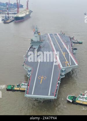 (240501) -- SHANGHAI, 1. Mai 2024 (Xinhua) -- ein Luftdrohnenfoto vom 1. Mai 2024 zeigt Schlepper, die Chinas dritten Flugzeugträger, die Fujian, von einem Dock im ostchinesischen Shanghai abschleppen. Chinas dritter Flugzeugträger, die Fujian, machte sich am Mittwochmorgen zu ersten Seeversuchen auf. Bei den Seeversuchen wird in erster Linie die Zuverlässigkeit und Stabilität der Antriebs- und elektrischen Systeme des Flugzeugträgers getestet. Seit seiner Markteinführung im Juni 2022 hat der Fujian seine Festmacherversuche, Ausstattungs- und Ausrüstungsanpassungen abgeschlossen. Sie hat die technischen Anforderungen für Versuche auf See erfüllt. ( Stockfoto