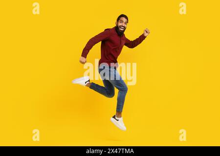 Mann in rotem Pullover, der in die Luft springt Stockfoto