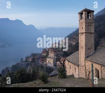 Eine sehr antike Steinkirche im kleinen Dorf Pognana Lario am Comer See mit Blick auf den See und die umliegenden Hügel, Italien Stockfoto