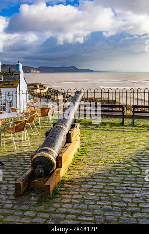 Eine historische Kanone, die erhalten und montiert wurde, um von der Bell Cliff Terrace in Lyme Regis, Dorset, England, Großbritannien, über die Jurassic Coast und die Lyme Bay zu blicken Stockfoto