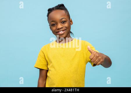 Süßer dunkelhäutiger Junge, der aufgeregt aussieht und schön lächelt Stockfoto