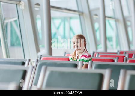 Kinder am Flughafen. Kinder schauen auf das Flugzeug. Reisen und Fliegen mit Kind. Familie am Abflugsteig. Urlaub und Reisen mit kleinen Kindern. Stockfoto