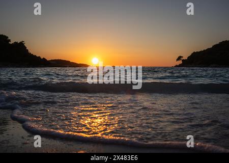 Niedriger Blick auf die Ionische Meereswelle während der Goldenen Stunde in Südalbanien. Welliges Wasser mit Sonnenuntergang in Ksamil. Stockfoto