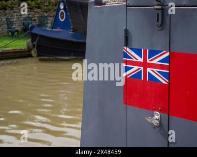 Gemalte Union Jack Flagge auf einer roten Umrandung auf einem schmalen Boot, das am Kanal bei Stoke Bruerne, Northamptonshire, Großbritannien, ankert Stockfoto