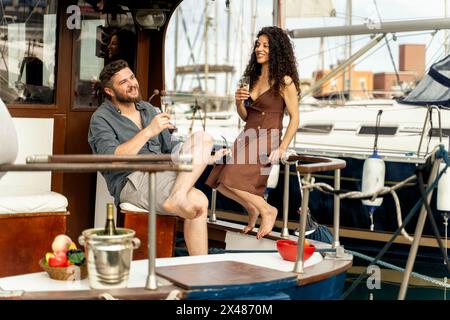 Erwachsene Mann und Frau - Paar genießt Sekt auf der Yacht - Sonnenuntergang Hintergrund, Luxus Freizeit, Urlaub Vibes - romantisch, Sommer. Stockfoto