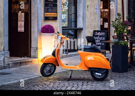 Vespa Special Piaggio in Vintage-Orange parkte vor einer Bar in einer italienischen Kopfsteinpflasterstraße. Stadt Udine, Region Friaul-Julisch Venetien, Italien. Stockfoto