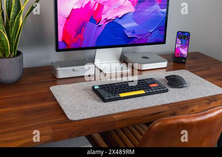 LONDON – 30. APRIL 2024: Apple Mac Computer im modernen Home Office, Arbeit von zu Hause aus, minimaler Schreibtischaufbau Stockfoto