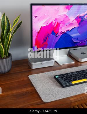 LONDON – 30. APRIL 2024: Apple Mac Computer im modernen Home Office, Arbeit von zu Hause aus, minimaler Schreibtischaufbau Stockfoto