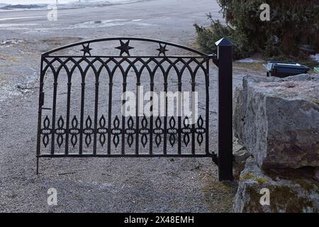 Altes dekoratives schmiedeeisernes Tor zu einem Friedhof. Stockfoto