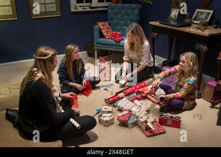 Mutter und Töchter verpacken Geschenke im Haus der Familie Dorset in Christmas, England, Großbritannien Stockfoto