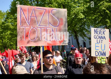 Hamburg, Deutschland. Mai 2024. Demonstranten halten Banner mit der Aufschrift "töte Nazis" und "werde die EU nie im Stich lassen" auf der Max-Brauer-Allee. Unter dem Motto "mehr Lohn, mehr Freizeit, mehr Sicherheit" forderten der Deutsche Gewerkschaftsbund (DGB) und seine Mitgliedsgewerkschaften am 1. Mai 2024, dem "Tag der Arbeit", Menschen auf, sich an den Aktivitäten zu beteiligen. Quelle: Georg Wendt/dpa/Alamy Live News Stockfoto