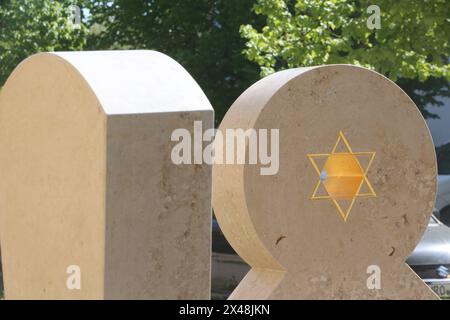 Blick am Mittwoch 01.05.2024 in Malchin Landkreis Mecklenburgische Seenplatte auf das neue Kunstwerk, das an die einstige Synagoge in der Stadt erinnert. In dieser gab es bis 1925 eine jüdisches Bethaus das von 1925 bis 1945 eine katholische Kapelle war. Diese wurde 1945 durch einen Brand zerstört. Jetzt wurden an ihrem früheren Ort im Stadtzentrum drei steinerne Stühle aufgestellt die von dem Bildhauer Michael Spengler stammen. Sie erinnern fortan an an das einstige jüdische Leben in der Stadt. *** Ansicht am Mittwoch 01 05 2024 im Malchin Landkreis Mecklenburgische Seenplatte des neuen Werkes Stockfoto