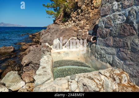 Die sogenannten Pausanias-Bäder in Methana, Griechenland, verfügen über einen kleinen Pool, der sich alle 15 Minuten füllt, damit Besucher das heiße Wasser genießen können. Stockfoto