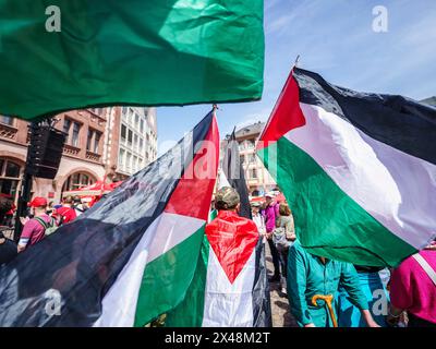 1. Mai 2024, Hessen, Frankfurt/Main: Ein Mann geht bei der Abschlussveranstaltung mit palästinensischen Fahnen über den Römerberg. Unter dem Motto "mehr Lohn, mehr Freizeit, mehr Sicherheit" forderten der Deutsche Gewerkschaftsbund (DGB) und seine Mitgliedsgewerkschaften am 1. Mai 2024, dem "Tag der Arbeit", Menschen auf, sich an den Aktivitäten zu beteiligen. Foto: Andreas Arnold/dpa Stockfoto