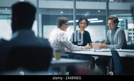 Vielfältiges Team von Managern, die im modernen Büro von Big City arbeiten und Gespräche führen. Kollegen arbeiten an neuen Geschäftschancen, der Vorstand hält eine Besprechung ab und spricht über Investitionen in die Zukunft. Stockfoto