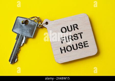 Unser erster Haustext ist auf hölzernem Schlüsselanhänger graviert. Stockfoto