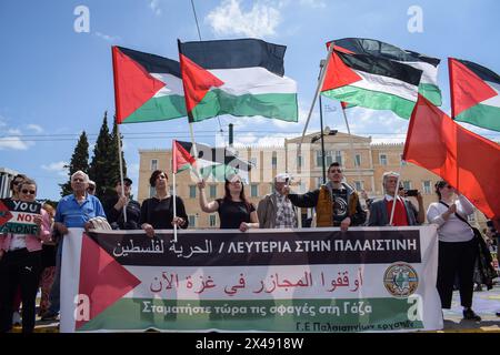 Athen, Griechenland. 1. Mai 2024. Die Demonstranten halten ein Banner mit der Aufschrift „Freiheit zu Palästina“ und schwenken während der Kundgebung zum Internationalen Wokertag palästinensische Fahnen. Tausende protestieren bei den Maikundgebungen gegen „hohe Preise und Lohnverluste, die die Gesellschaft zu einer dauerhaften Verarmung treiben“. Quelle: Dimitris Aspiotis/Alamy Live News Stockfoto