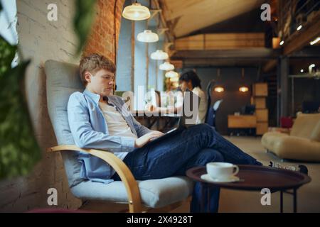 Dynamischer Arbeitsbereich. Lebendiger Coworking-Raum mit jungen Menschen, Studenten und Mitarbeitern, die in verschiedenen Aktivitäten tätig sind, arbeiten, studieren Stockfoto