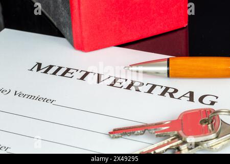 Symbolbild des Mietvertrags: Nahaufnahme eines Mietvertrags und Schlüssel für die Haustür Stockfoto