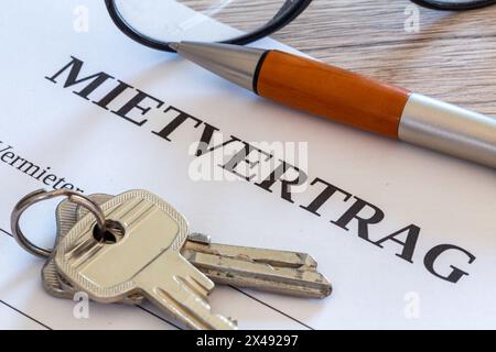 Symbolbild des Mietvertrags: Nahaufnahme eines Mietvertrags und Schlüssel für die Haustür Stockfoto