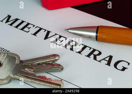 Symbolbild des Mietvertrags: Nahaufnahme eines Mietvertrags und Schlüssel für die Haustür Stockfoto