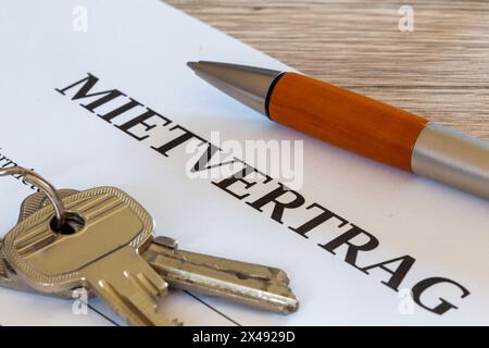 Symbolbild des Mietvertrags: Nahaufnahme eines Mietvertrags und Schlüssel für die Haustür Stockfoto