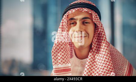 Porträt eines erfolgreichen muslimischen Geschäftsmannes im traditionellen Outfit, der für die Kamera posiert, sanft lächelnd. Saudi, Emirat, Arabisches Geschäftsmann-Konzept. Stockfoto