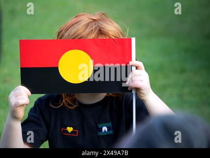 Kid hält die australische Aborigine-Flagge an einem öffentlichen Event Australia Day Stockfoto