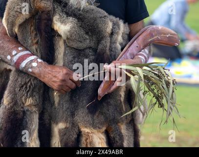 Die menschliche Hand hält rituelle Klappern für den Willkommensritus bei einer indigenen Gemeinde in Australien Stockfoto